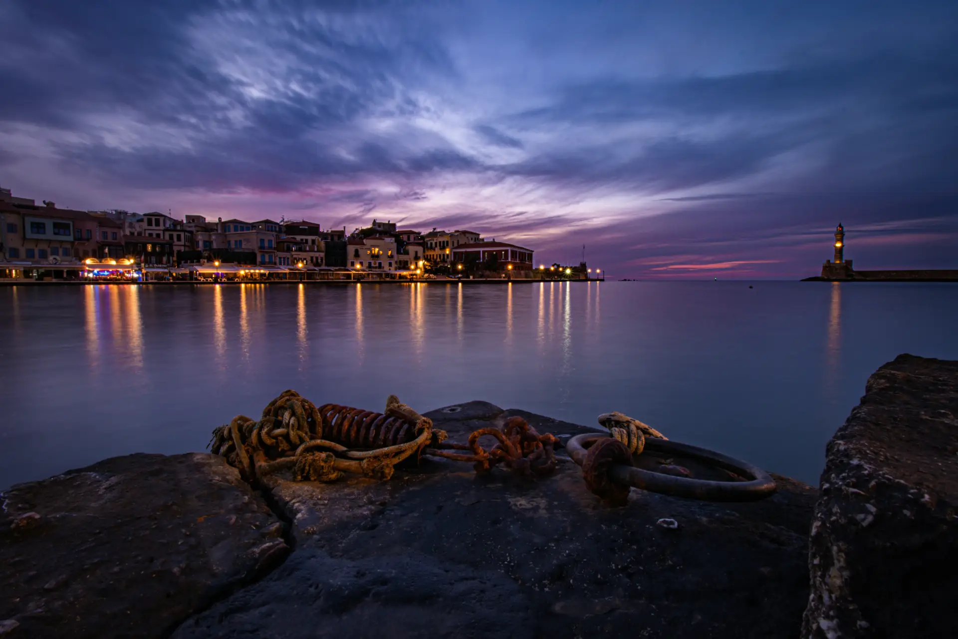 harbor of Chania at dusk, with the lighthouse at the background