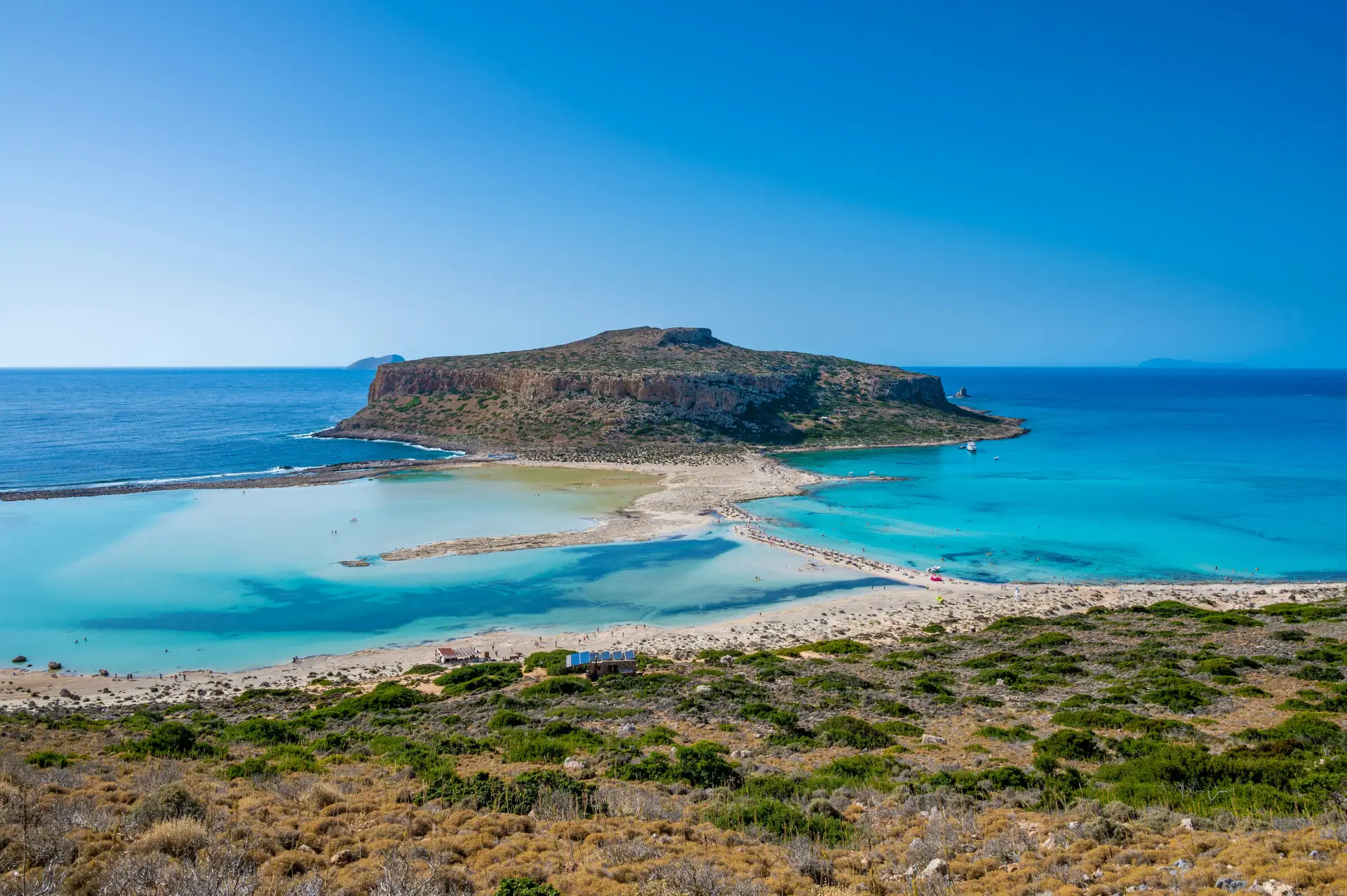 overview of balos lagoon with blue water and greenery at the coast