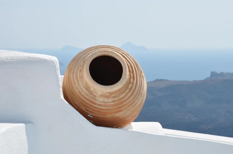 view of a kioupi standing in a white wall overlooking the aegean sea