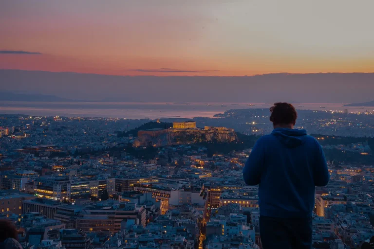 How Plous Designs a Journey Through Greece 2 evening panoramic view of acropolis and a man taking its picture