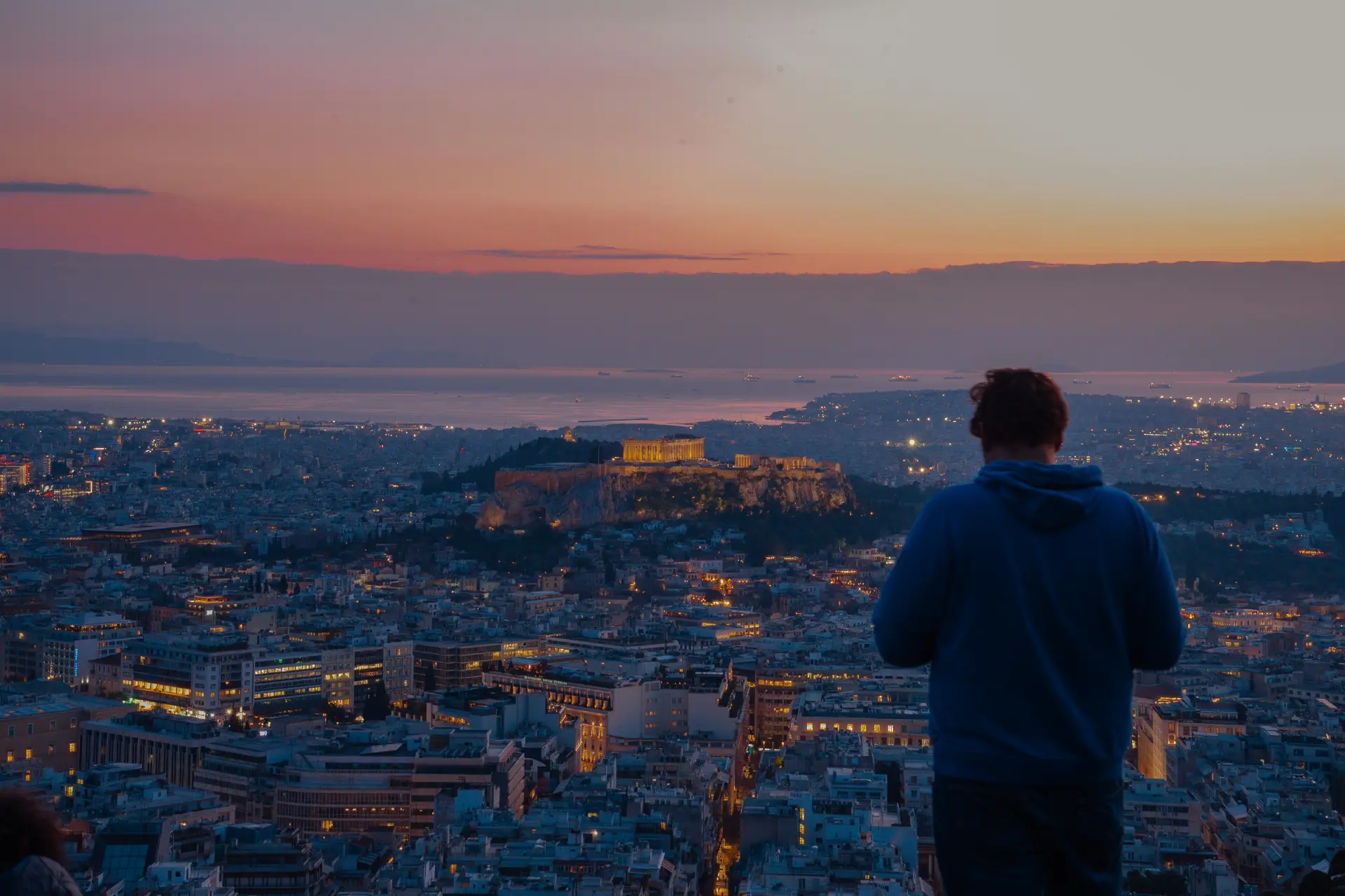 How Plous Designs a Journey Through Greece 1 evening panoramic view of acropolis and a man taking its picture