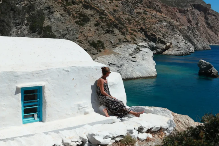 a woman sitting in the top of a church overlooking the sea