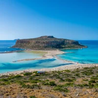 overview of balos lagoon with blue water and greenery at the coast